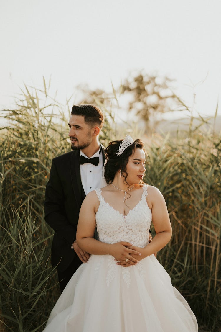 Bridegroom Holding His Bride By The Tall Grass