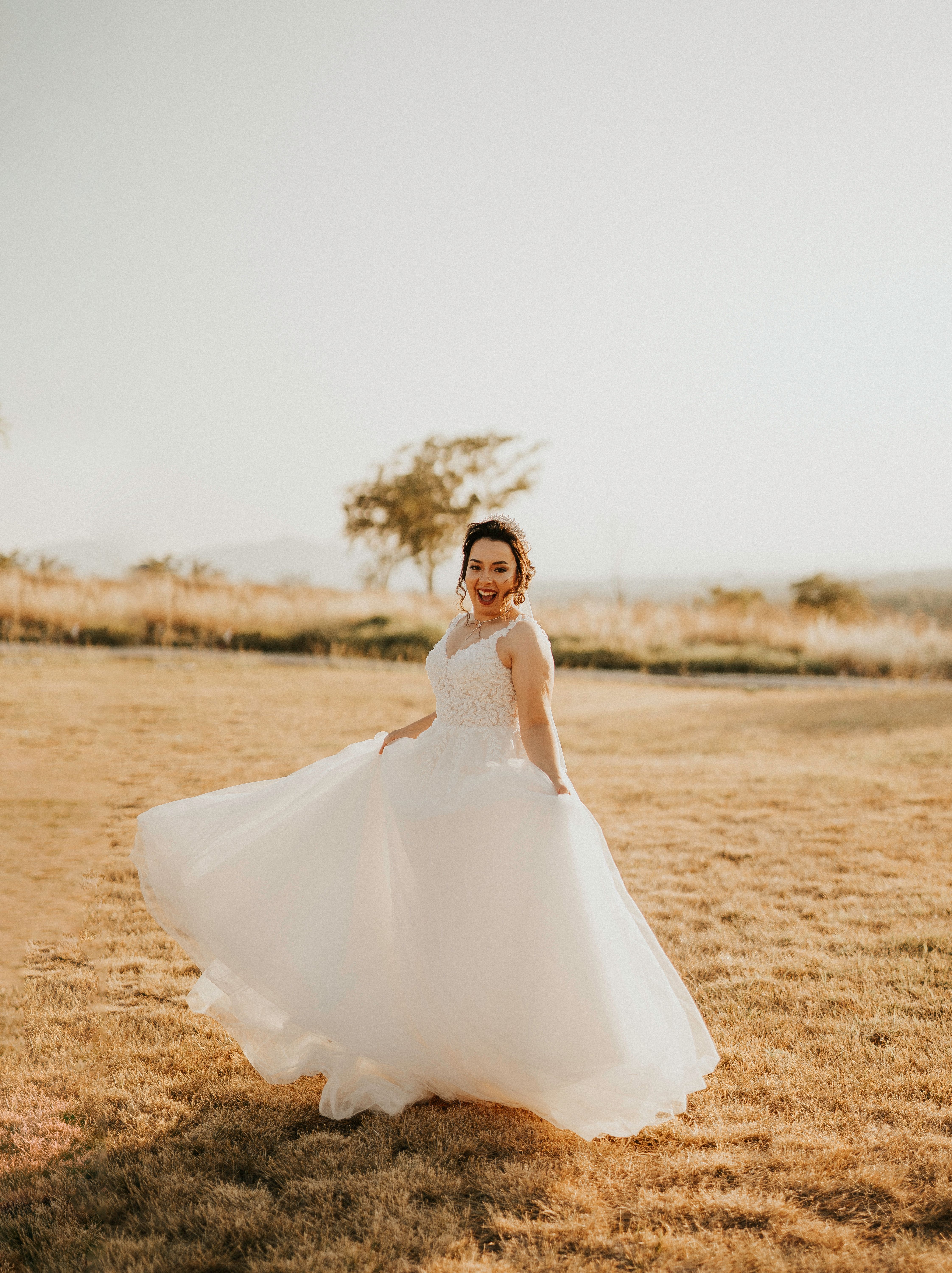 Woman in White Wedding Dress Standing on Brown Grass Field · Free Stock ...