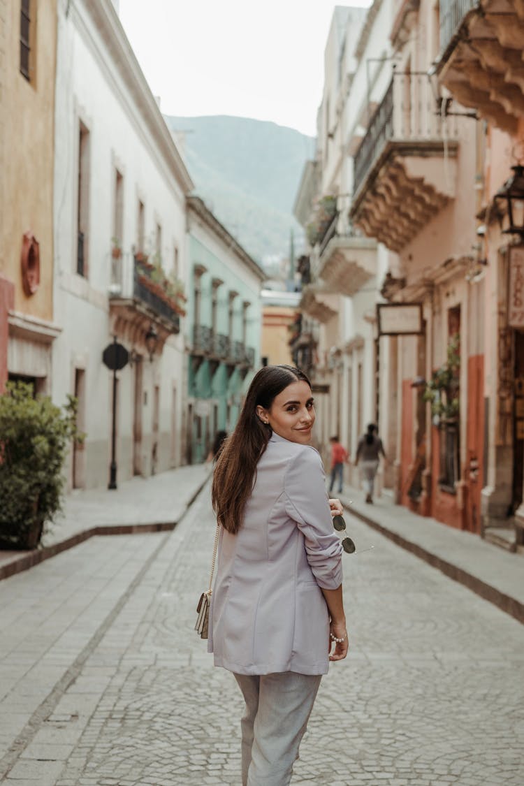 Brunette Walking Cobblestone Street