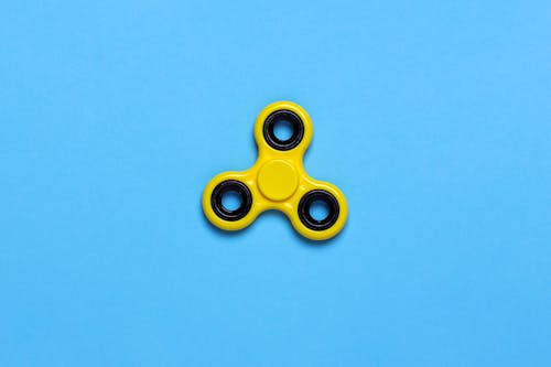 Gelbes Tri Spinner Zappelspielzeug Auf Blauer Tischplatte