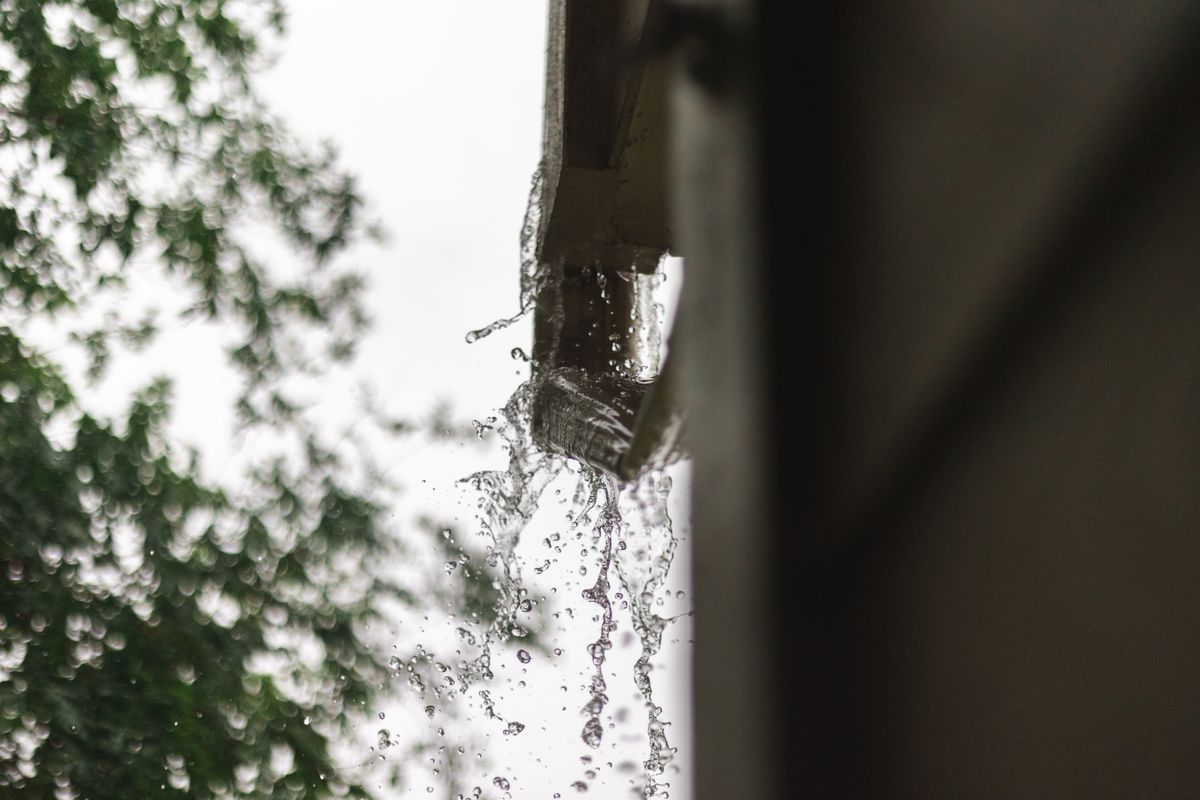 Close-up of rainwater flowing off a freshly fitted gutter