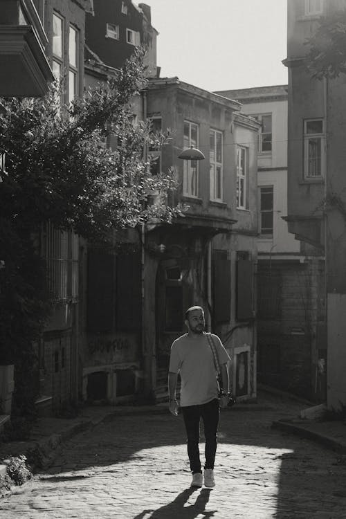 Free Grayscale Photo of Man Walking on the Street Stock Photo