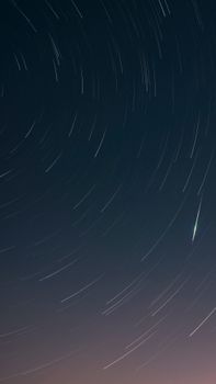 Dramatic star trails showcase the night sky's motion in this long exposure photograph.