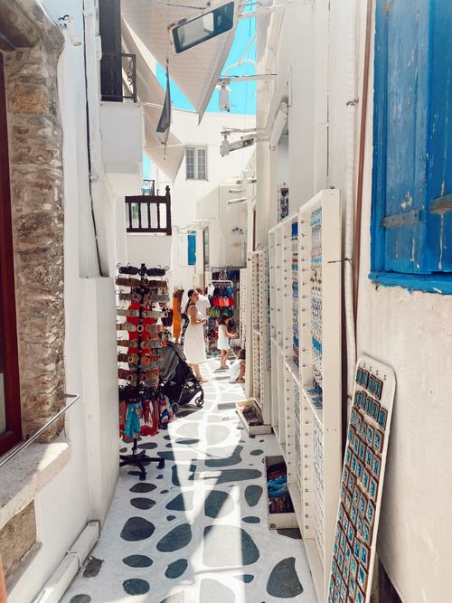 Free Explore a quaint alleyway with whitewashed buildings and vibrant details on a Greek island. Stock Photo