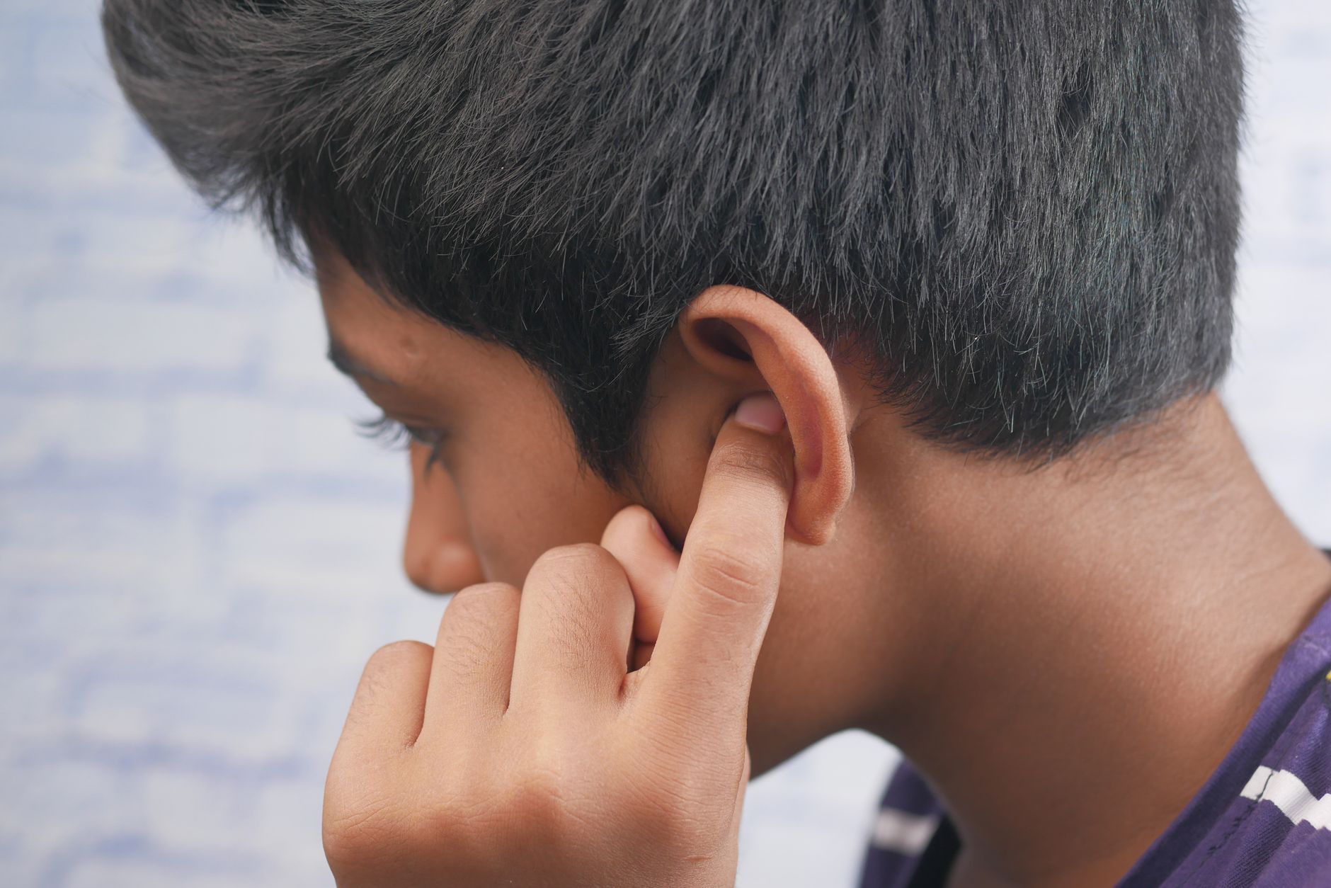 Un professionnel de santé ajustant une aide auditive dans l'oreille d'un patient pour traiter l'hypoacousie.