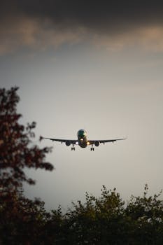 A silhouette of an airplane landing during sunset in Hamburg, Germany.