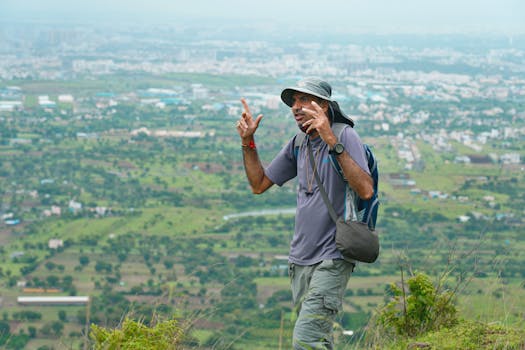 Man on a hike with a beautiful view of Pune city in the background, showcasing adventure and nature.