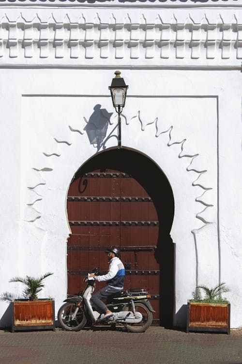 Man on a Motorbike in front of Arched Door in Marrakesh, Morocco 