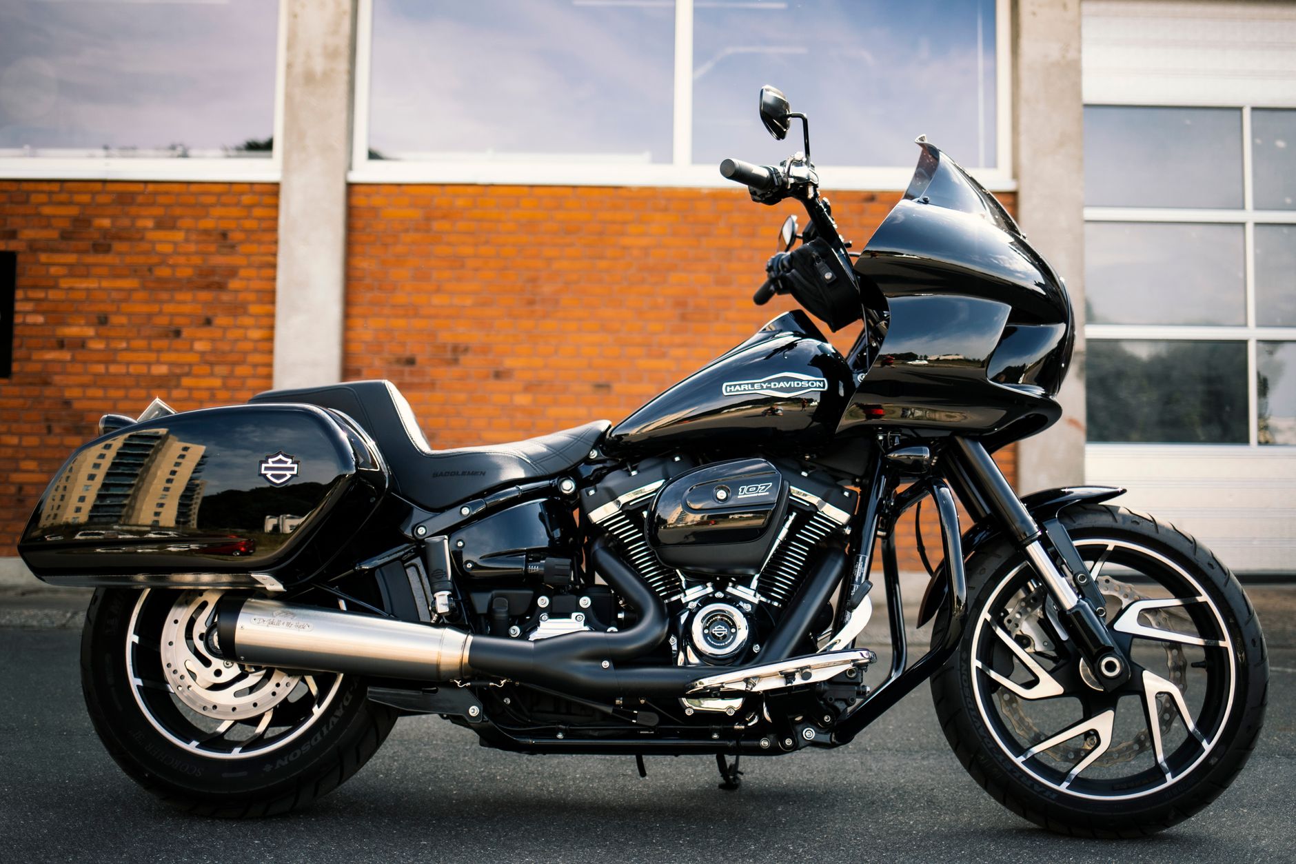 Black motorcycle parked in front of a brick building in Silkeborg, Denmark, showcasing its sleek design.