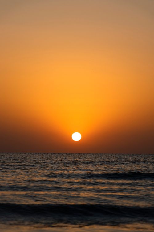 Free Beautiful sunset casting golden hues over the sea horizon in Tabriz, Iran. Stock Photo