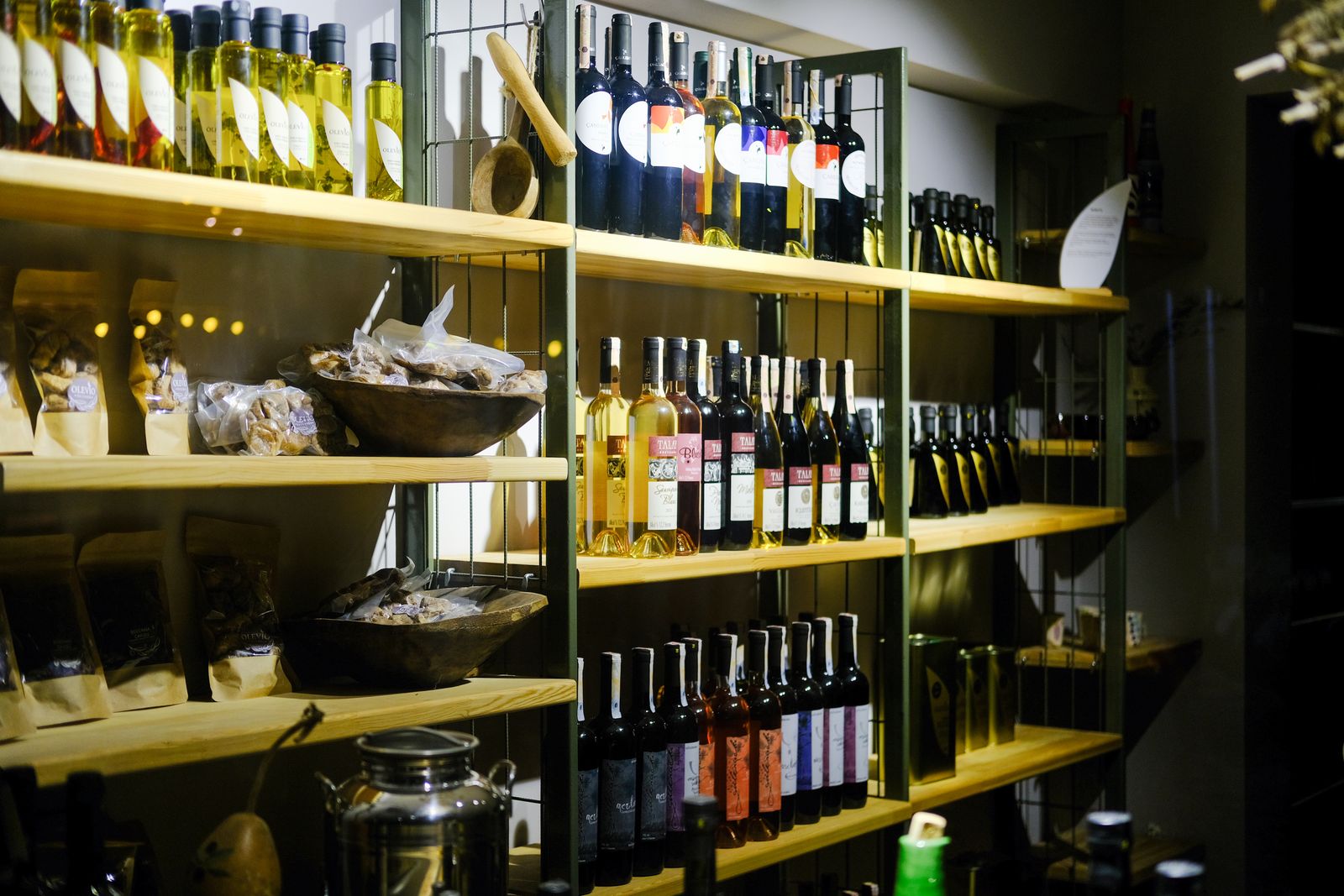 Étagères de bois garnies de bouteilles de vin naturel à la cave Fragile