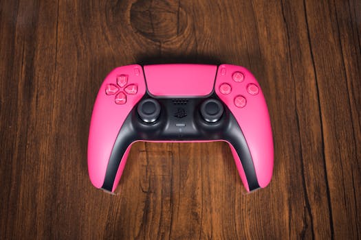 Close-up of a pink gaming controller on wooden texture, vibrant and stylish.