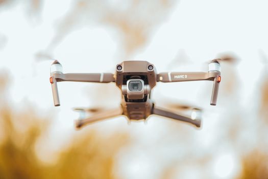 A cutting-edge drone flying outdoors, showcasing advanced aerial capabilities with a clear blue sky backdrop.