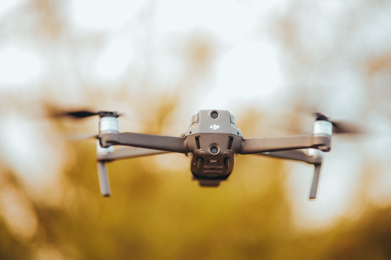 a close up view of a drone in flight against a warm blurred background
