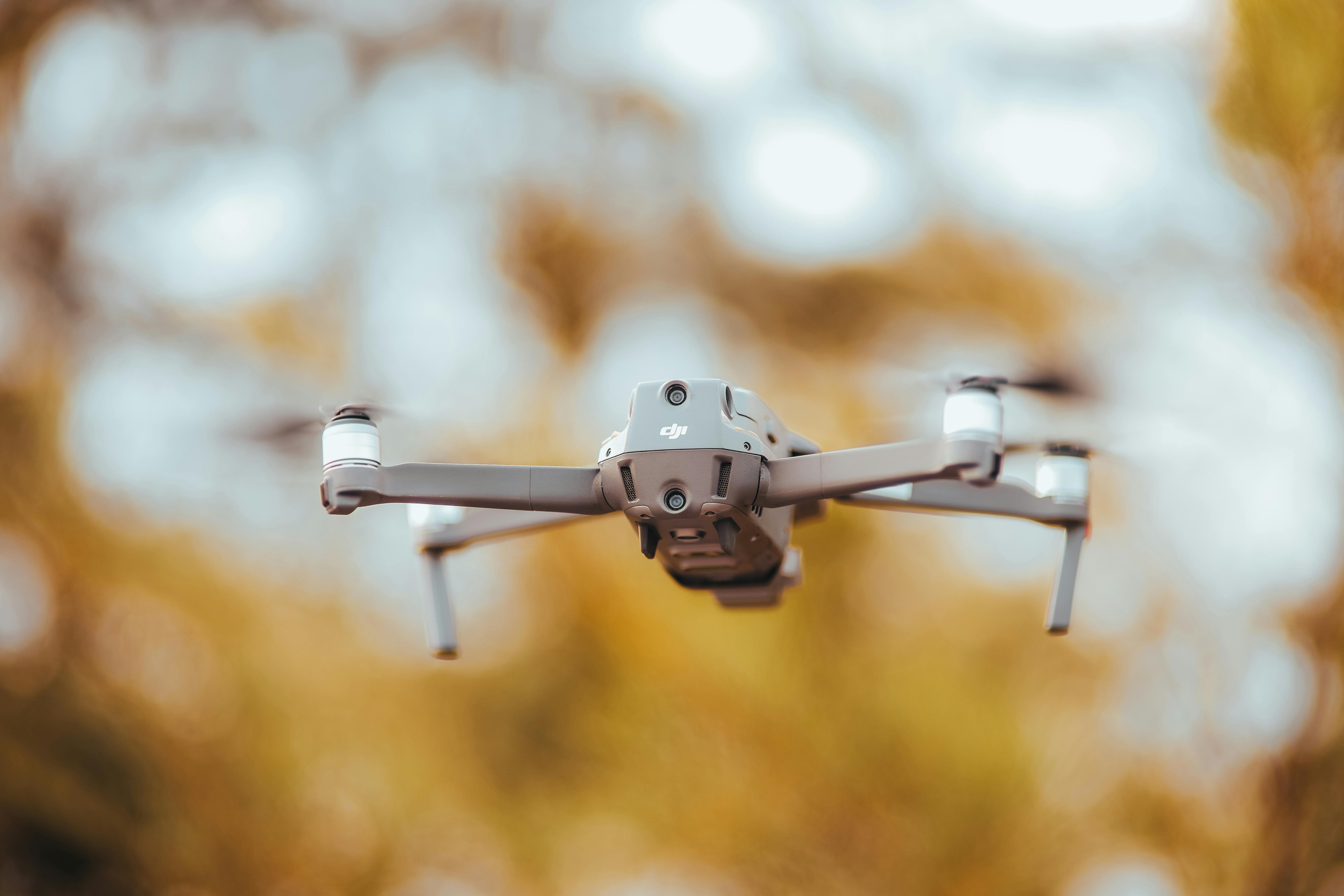 A detailed image of a drone in flight with a blurred natural background, captured outdoors.