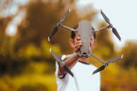 A Person Holding a Gray Drone Camera
