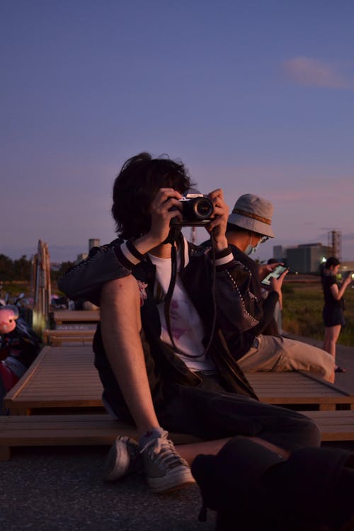 Person Wearing Jacket Taking Photo with a Camera