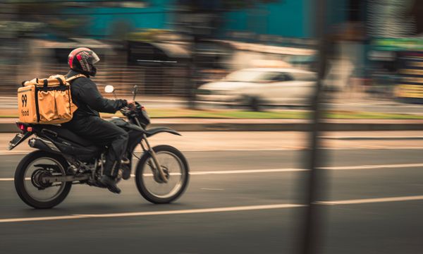 Motorbike & Bicycle Courier โ Motorcycle deliveryman speeds through city streets, showcasing fast food service.