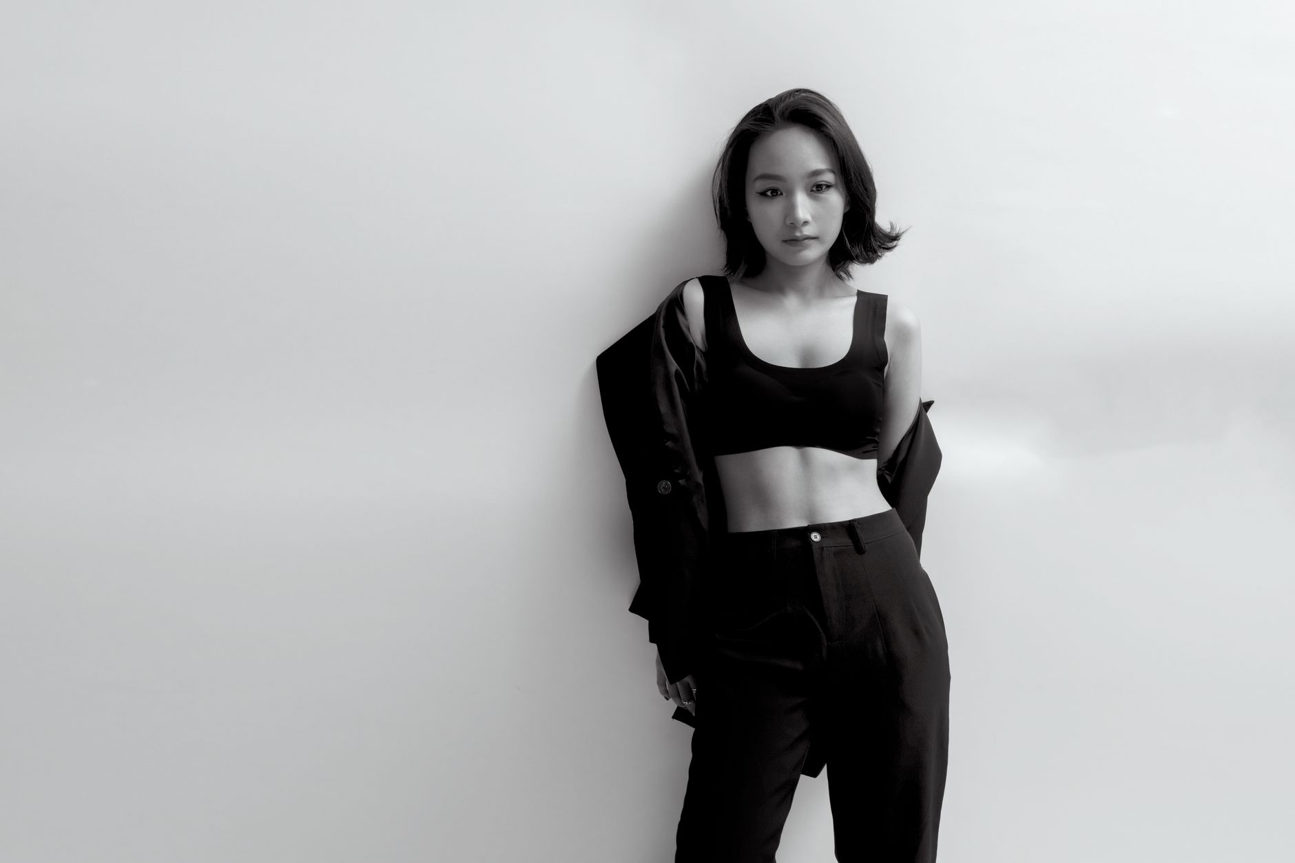 Stylish black and white portrait of a woman posing in a studio setting.