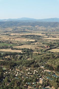 Explore a vast rural landscape featuring fields, farms, and rolling hills beneath a clear sky.