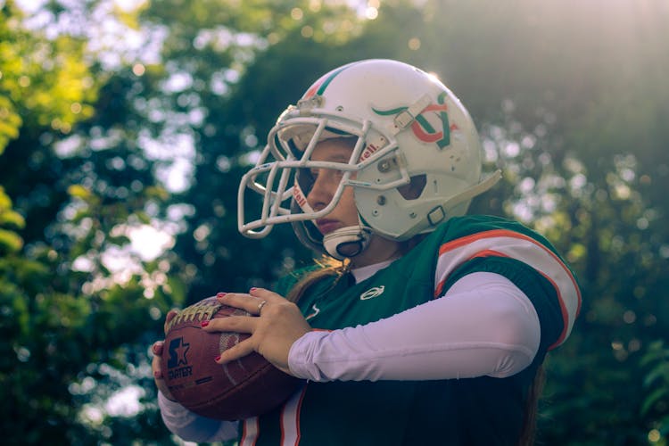 Woman In Uniform Playing American Football