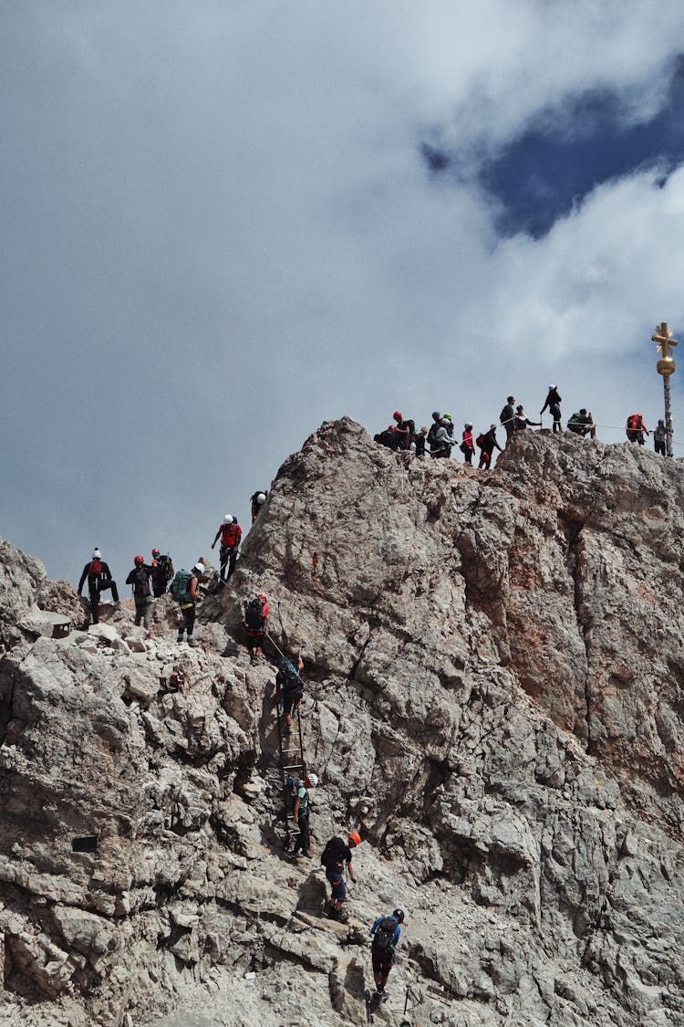 People Climbing On Mountain