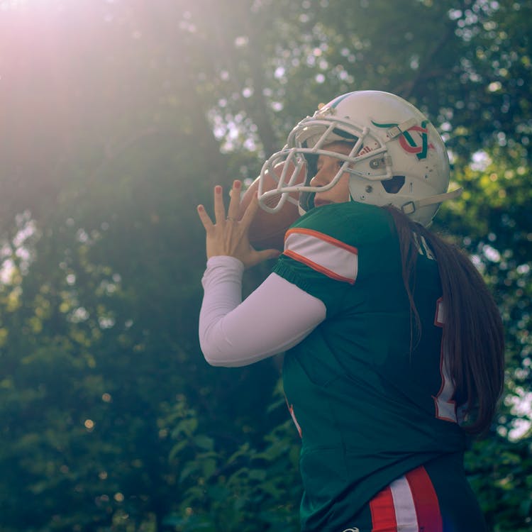 Woman In Green And Red Jersey Shirt Holding A Football