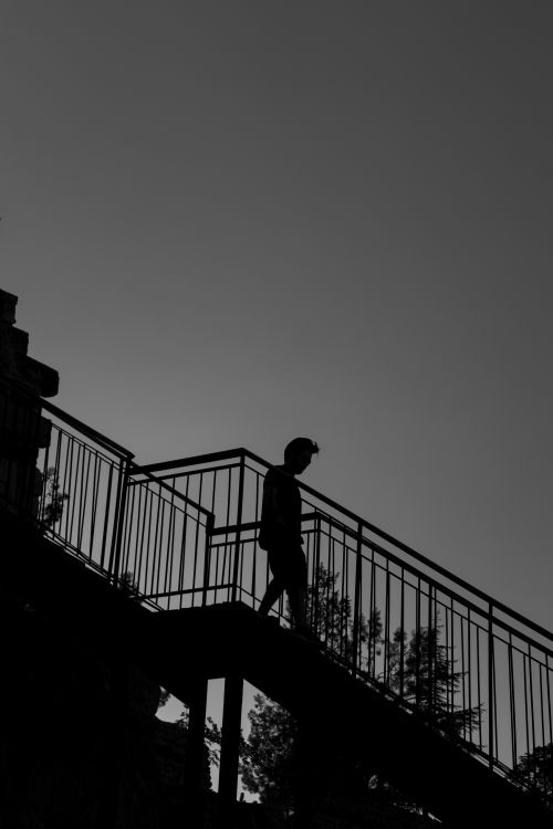 Free A striking silhouette of a person walking down stairs against a twilight sky in Talas, Türkiye. Stock Photo