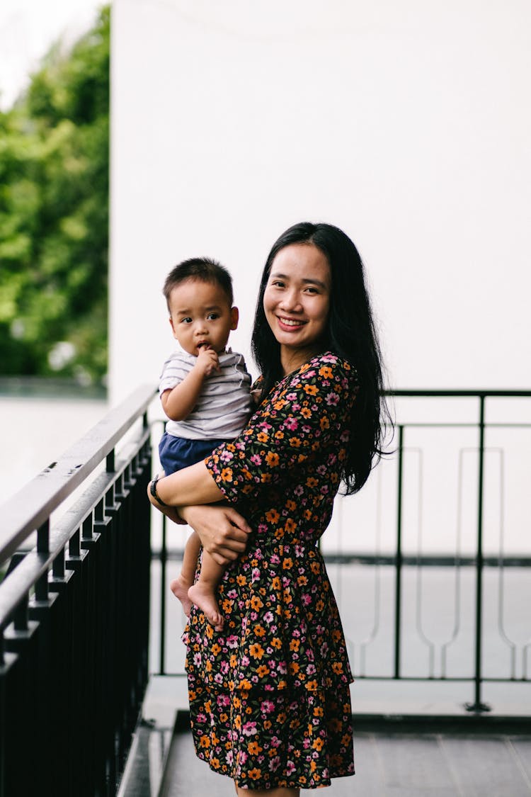 Mother Holding Baby On Balcony