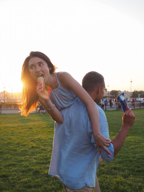 Free Young couple having fun with ice cream in a park at sunset, capturing joyful and playful moments. Stock Photo