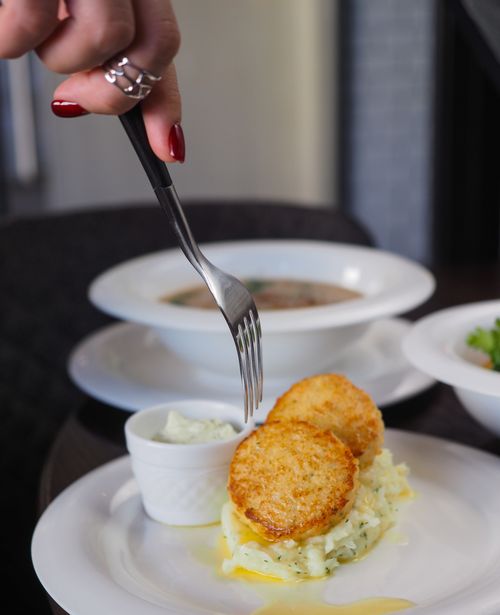 Free Close-up of hash browns with creamy sauce, emphasized with a fork for fine dining. Stock Photo