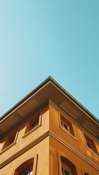 Low angle view of a vibrant yellow building in Istanbul, Türkiye, against a clear blue sky.