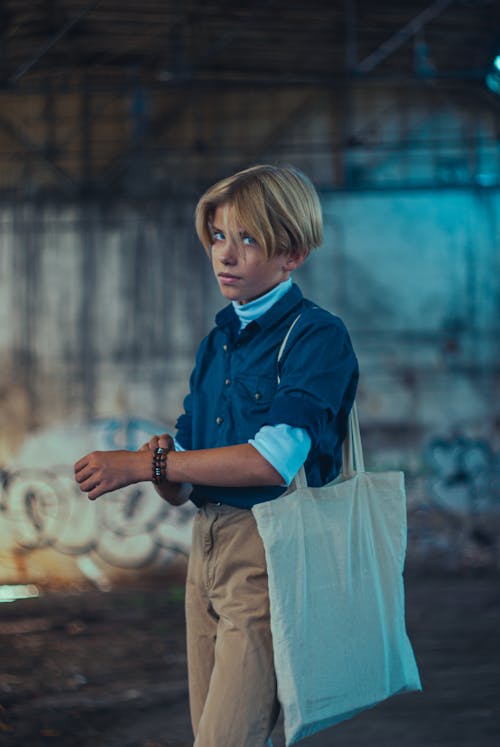 Woman with Short Hair and a Tote Bag Standing in an Abandoned Building