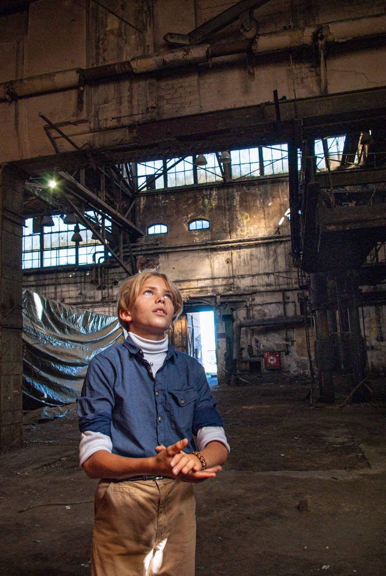 Man In Blue Button Up Shirt Standing Inside Abandoned Building