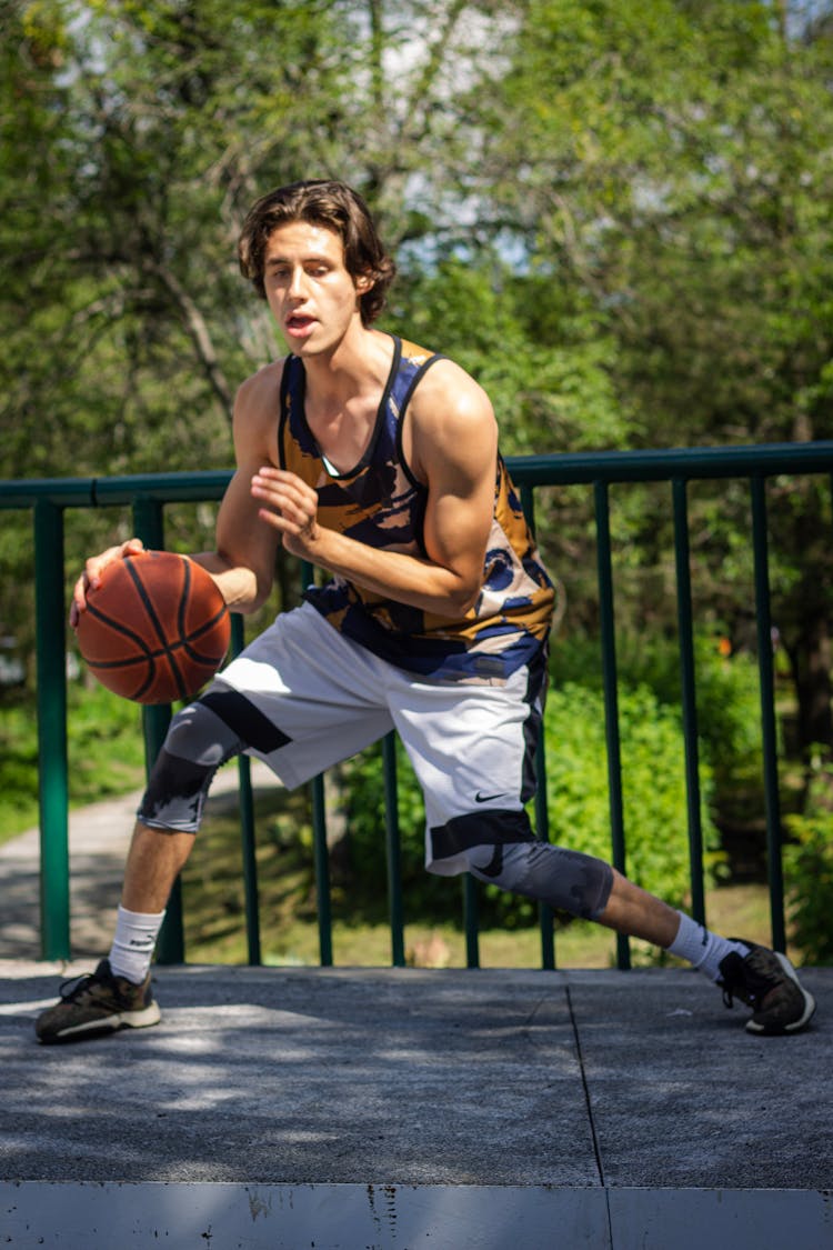 A Man Dribbling A Basketball