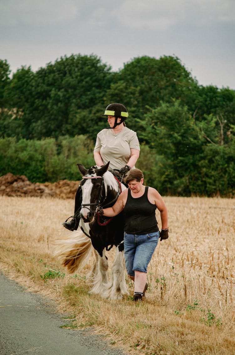 Woman Riding On Black And White Horse 