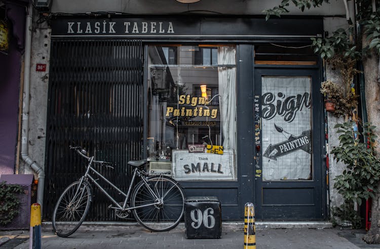 Facade Of A Shop With Painting On Wooden Frame Glass Door And Display Window