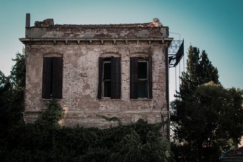 Free Eerie abandoned brick house surrounded by overgrown trees in Istanbul. Stock Photo