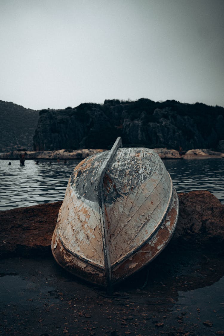 Abandoned Rustic Wooden Sailboat On Shore