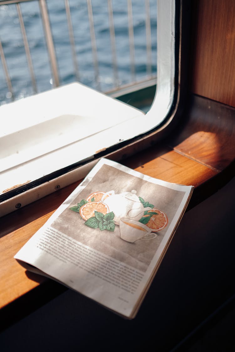 A Close-Up Shot Of A Magazine On A Window Sill