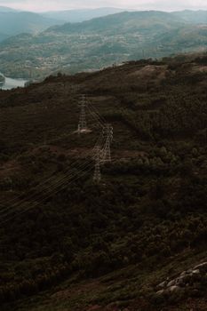 Aerial view of transmission towers amid lush green hills in daytime.