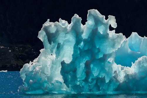 Free A stunning iceberg with turquoise hues floating in Arctic waters, melting under sunlight. Stock Photo