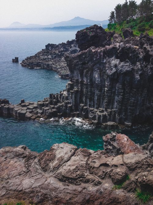 Free A breathtaking cliffside view at Daepo Jusangjeollidae showcasing unique volcanic rock formations. Stock Photo