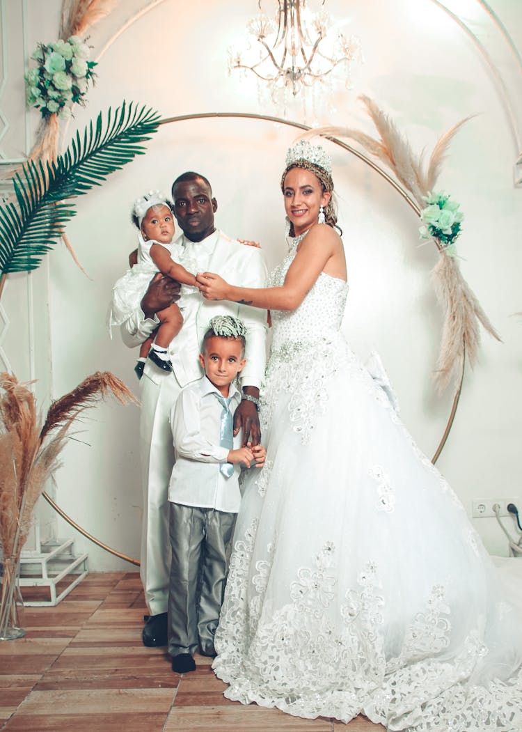 Mother And Wedding Dress Posing With Children And Father