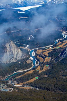 Breathtaking aerial view of a winding river through Banff's stunning valley landscape.