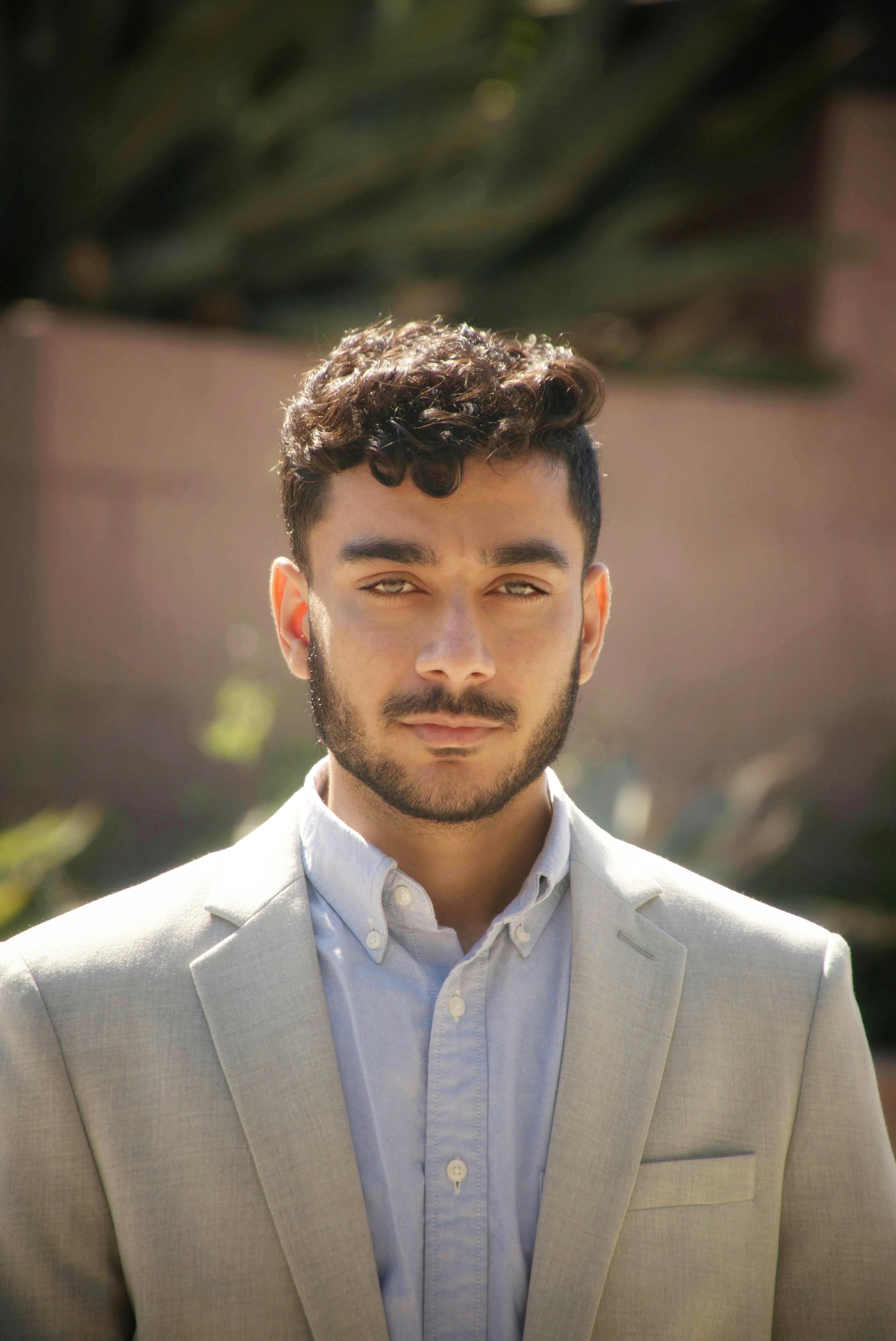 Young man in formal attire posing outdoors, ideal for business or lifestyle imagery.