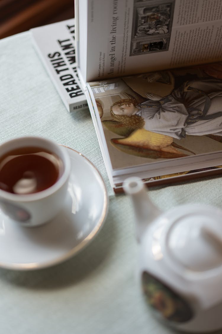 Books, Tea Cup And A Teapot On A Table 