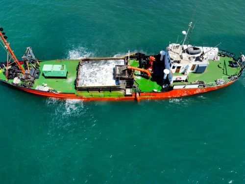 Free Drone shot of a fishing boat navigating the vibrant turquoise ocean waters, showcasing maritime activities. Stock Photo