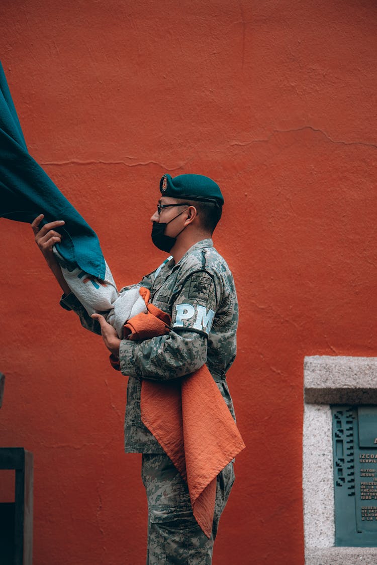 Soldier With Face Mask Holding Flag In Hands