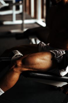 Close-up of strong, muscular legs working out on gym equipment indoors.